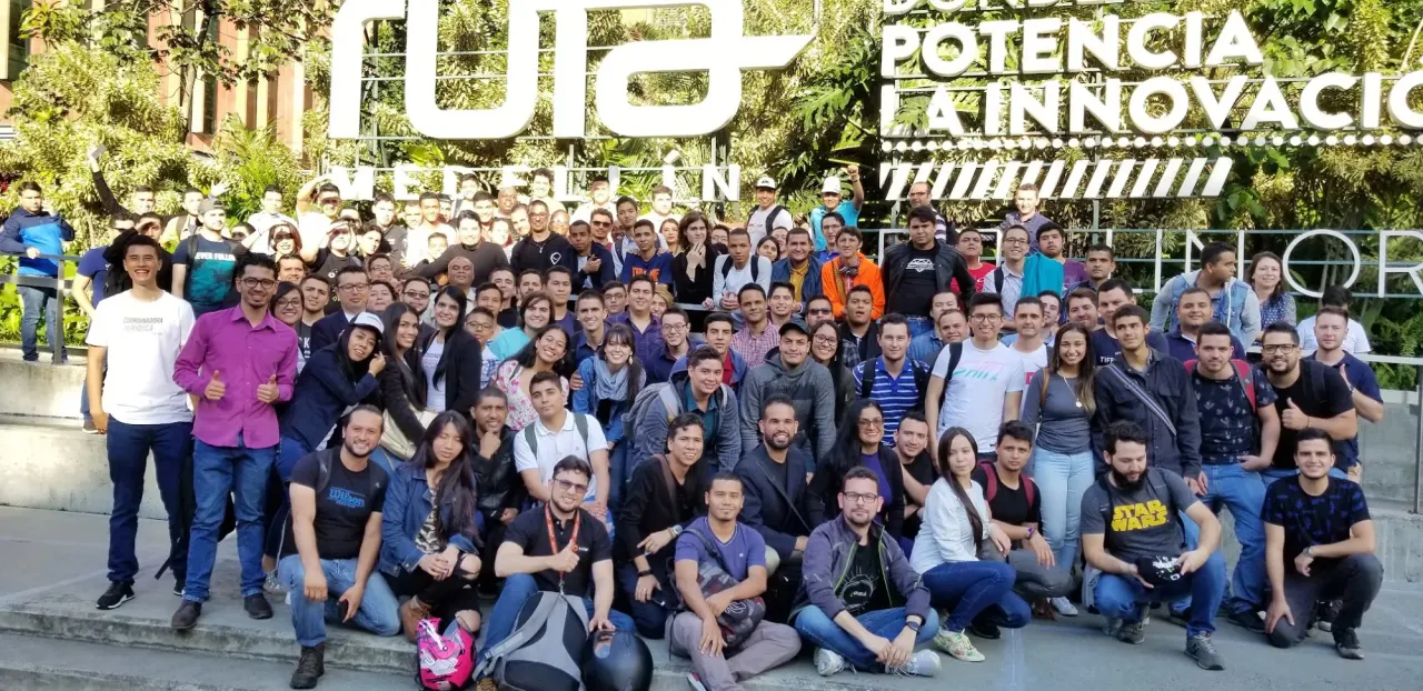 Foto de grupo de Andrés Londoño con más de cien asistentes frente al letrero de Ruta N Medellín