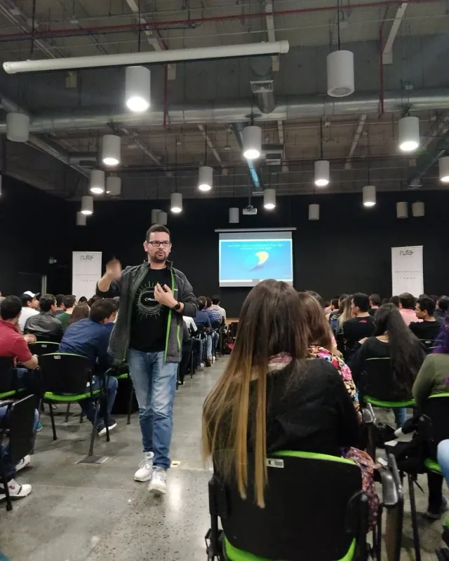 Andrés Londoño con camiseta de Platzi caminando entre el público de una charla en Ruta N Medellín